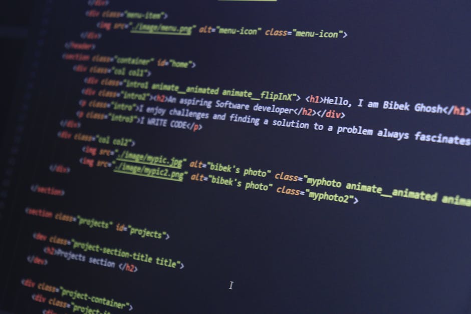 Close-up image of a computer screen displaying lines of HTML code with syntax highlighting in various colors such as yellow, blue, red, and green. The code includes tags for headings, div sections, im